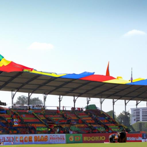 Khung cảnh toàn cảnh sân vận động đông đúc trong trận đấu U19, các cờ đội bóng màu sắc phấp phới trên khán đài
